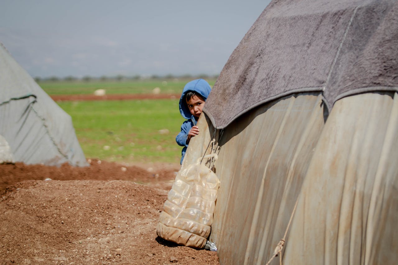 A Boy Hiding Behind a Tent