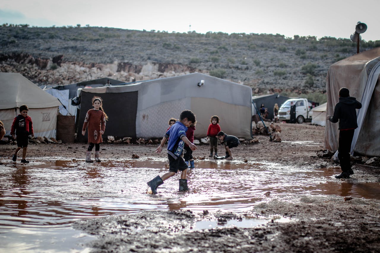 Children Playing in the Mud in a An Aerial View of a Refugee Camp